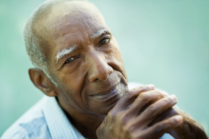 A person in deep thought, with their hands cupped together in front of their chin.