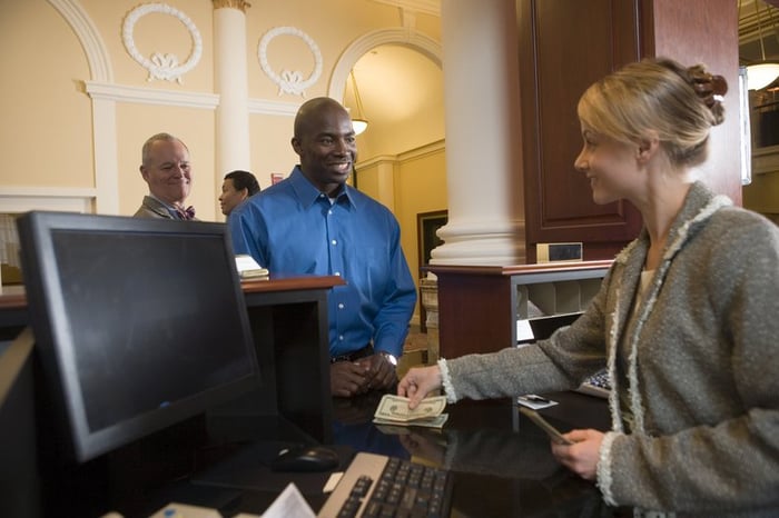 Bank teller assisting a customer with cash transaction.