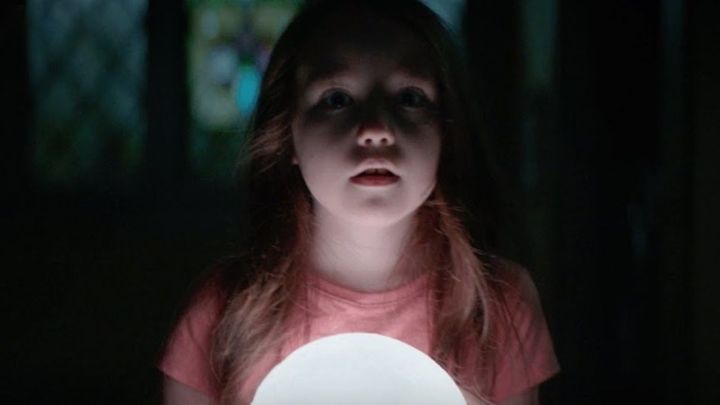 A young girl holding a lamp and looking scared in the movie "The Boogeyman."