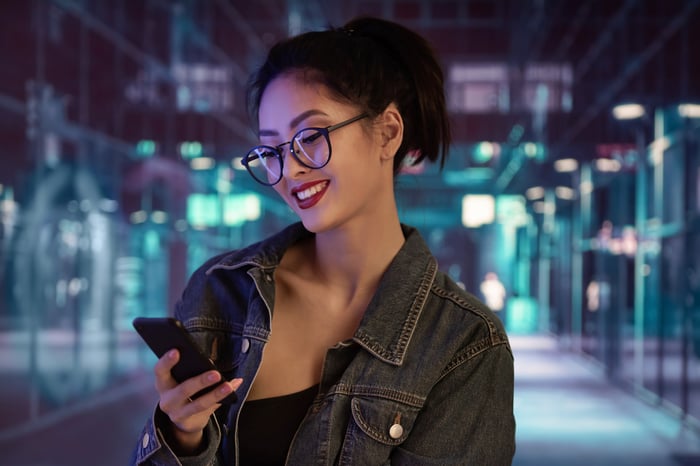 A person uses a smartphone at a subway station.