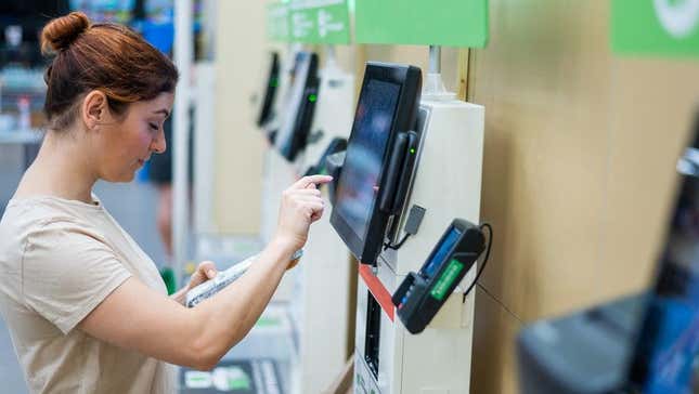 A woman uses a self-checkout kiosk