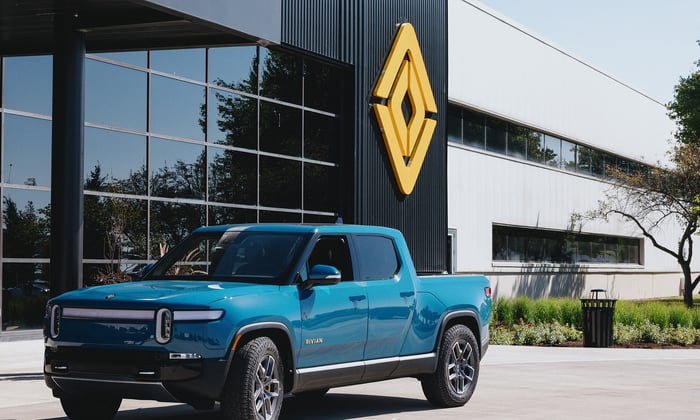 A Rivian truck in front of a building.