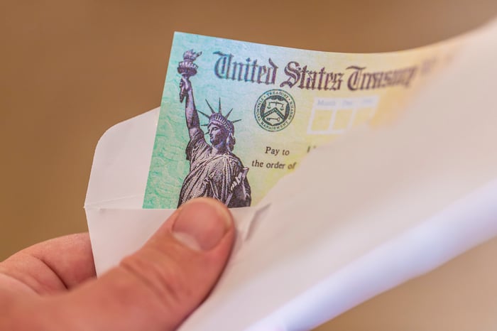 A person holding a check from the U.S. Treasury.