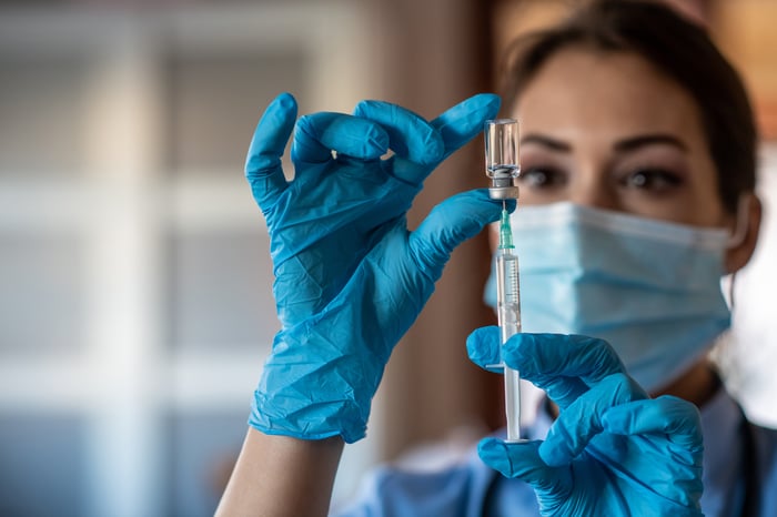 A healthcare worker prepares a vaccine dose.