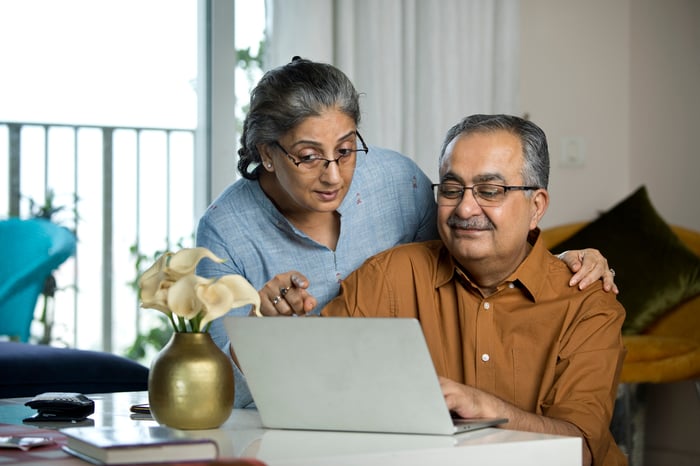 Two people looking at a laptop together.