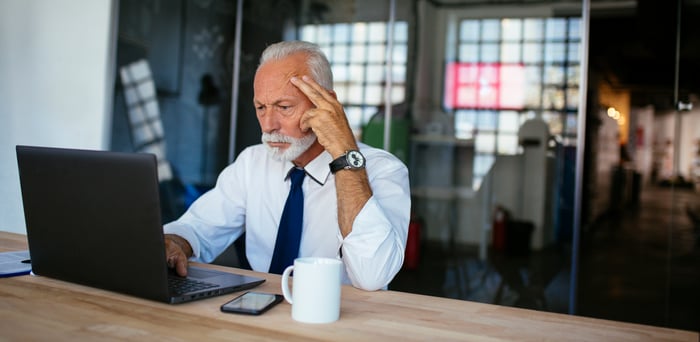 Person in office looking at laptop.