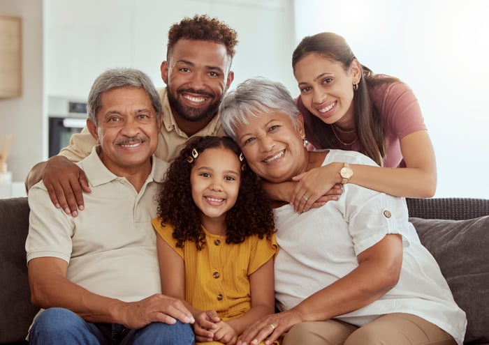 Four smiling adults and a smiling child looking forward.