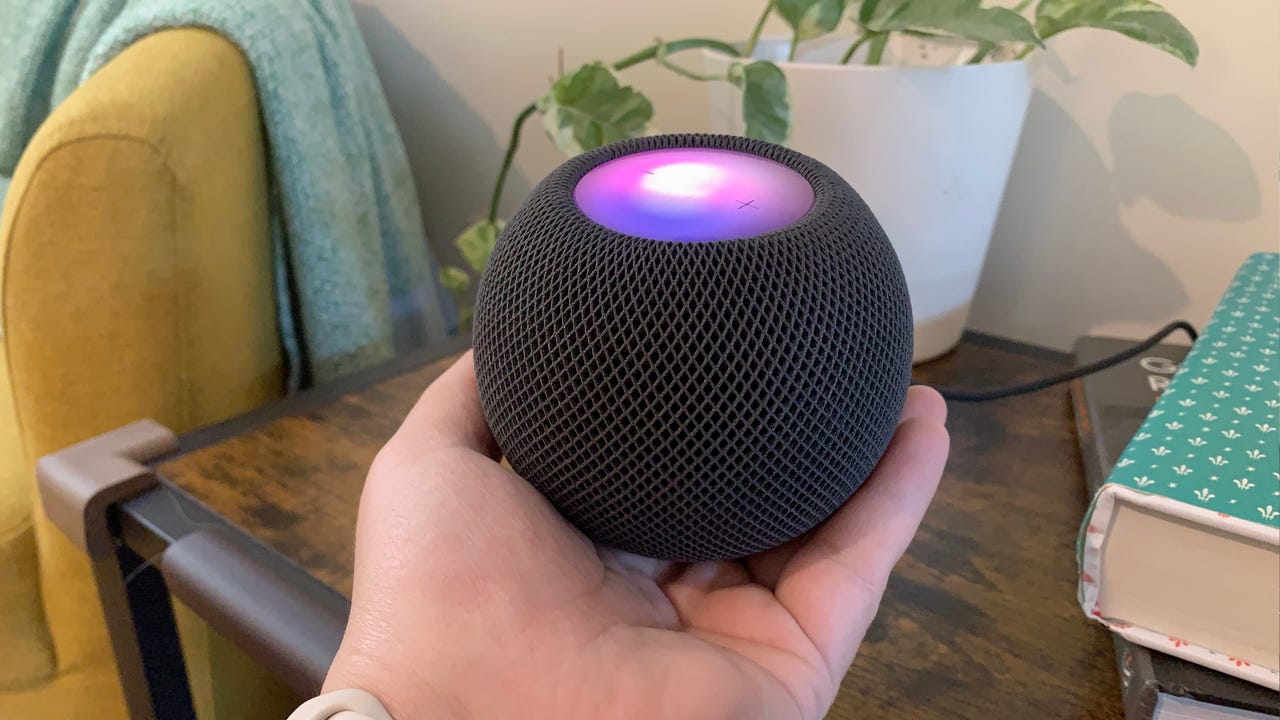 Hand holding a HomePod Mini