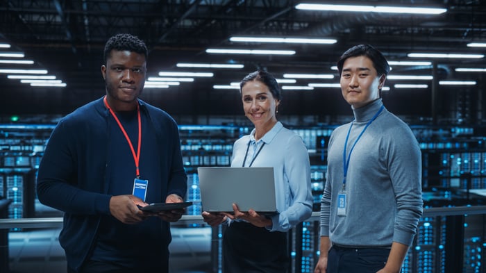 Three people in a data center.