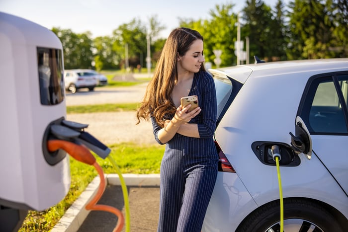 Driver waits for an electric vehicle to charge.