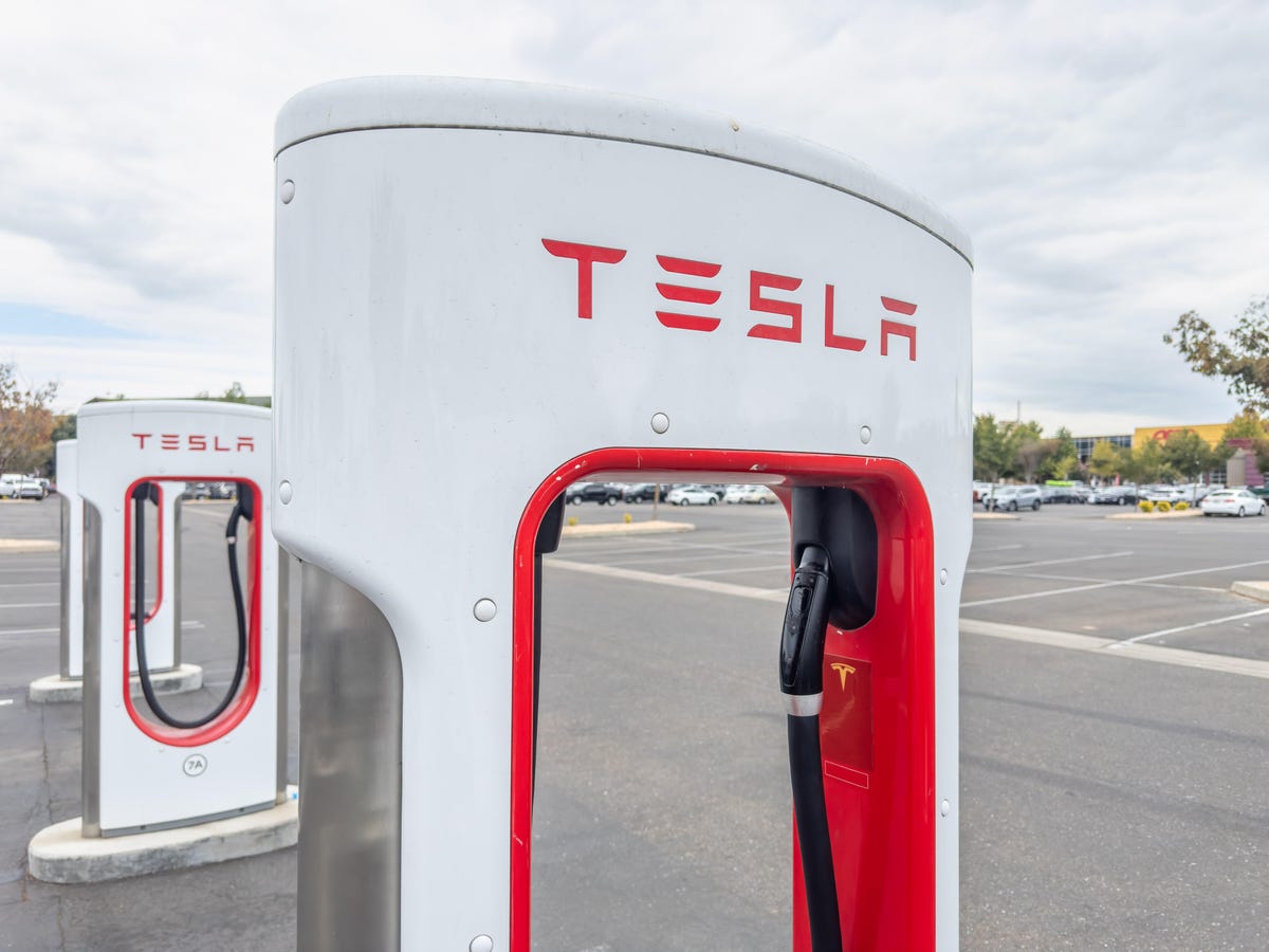 A red and white Tesla Supercharger for charging electric vehicles