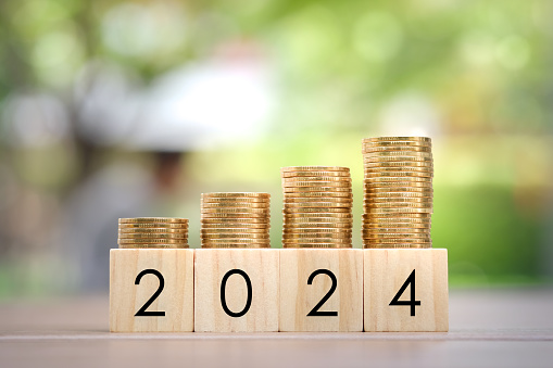 2024 New Year, New year economy growth, Planning to get money for prepare family or life budget, Annual TAX, Business and investment concept. Growth of coins stack on wood blocks number 2024.