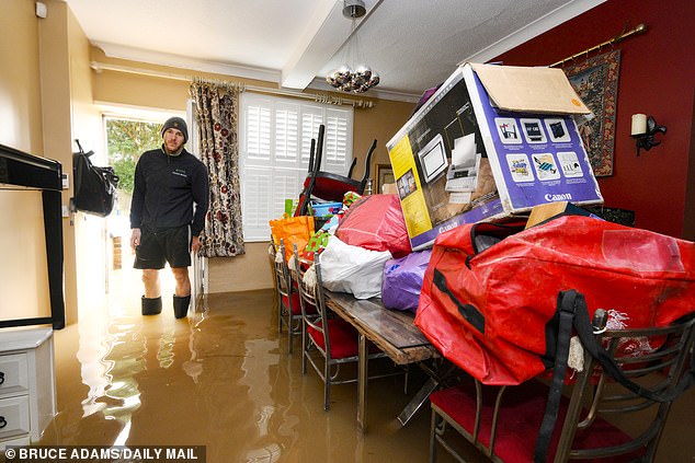 Matthew Bloodworth in his flooded home opposite Tewkesbury Abbey in Gloucestershire, after Storm Henk hit the UK last week