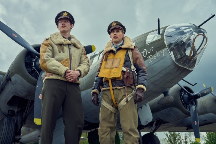 Callum Turner and Austin Butler stand near a plane in Masters of the Air.