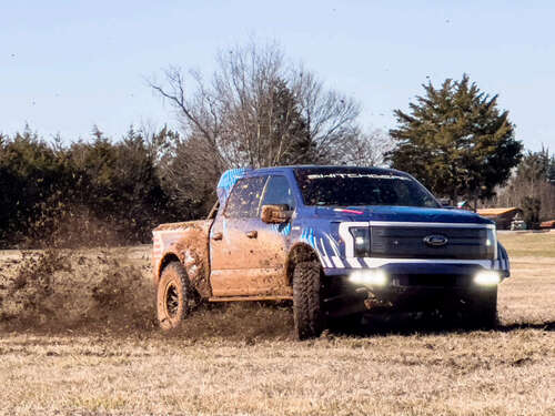 A Ford F-150 Lightning Switchgear sprays mud as it turns