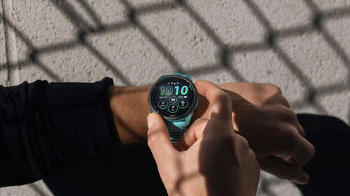 A Garmin Forerunner 265 on a user's wrist highlights the device's bright AMOLED display.