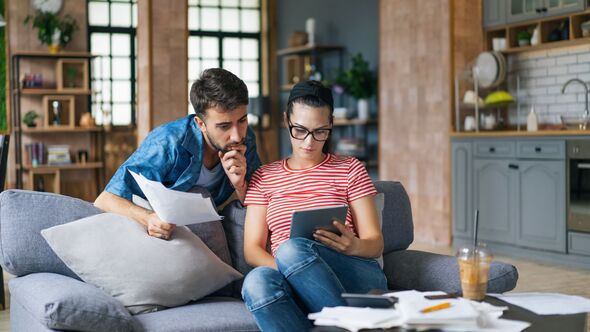 Couple calculating bills at home using tablet