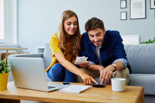 Couple smiling while calculating finances