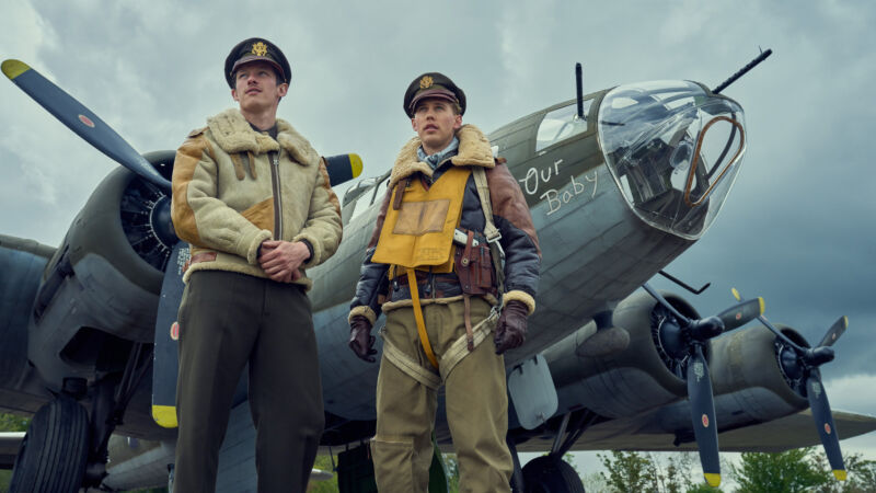 Photograph showing two stars of the show standing in front of a B-17