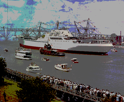 A large ship is shown near a bridge with a tugboat and several other smaller ships nearby.