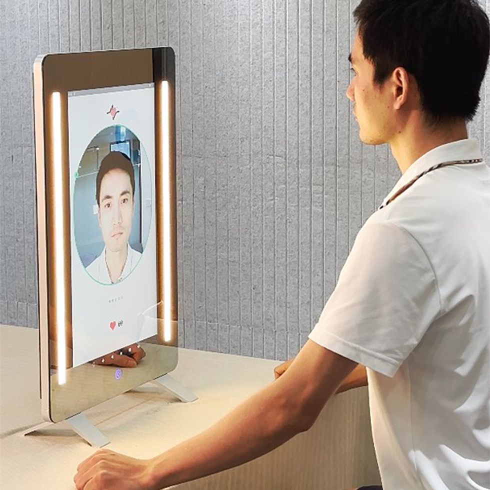 a man sitting in front of a rectangular tabletop mirror