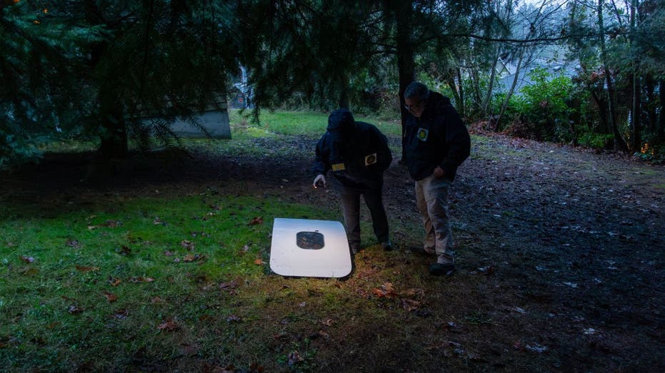 Two investigators examine a plane door