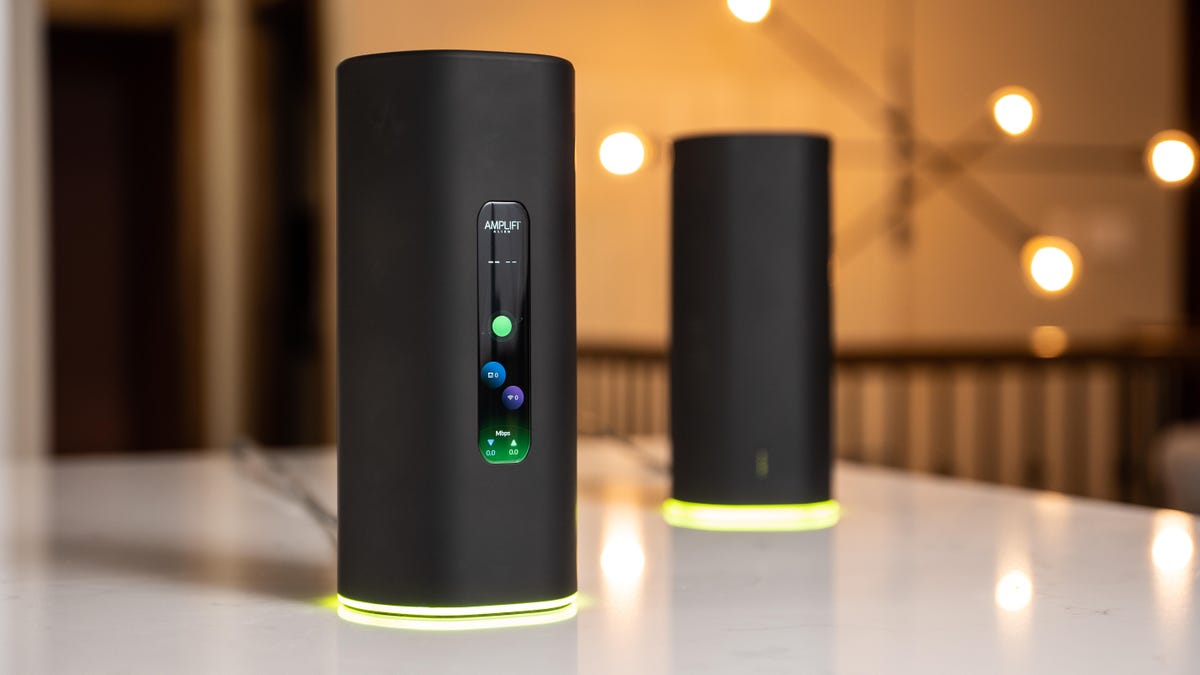 Two black Amplifi Alien routers on a white countertop.