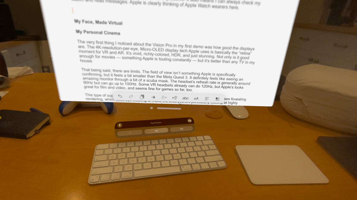 A virtual monitor hovering over a real keyboard and trackpad on a desk