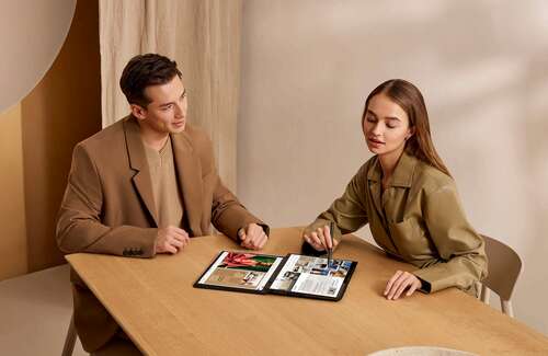 A man and a woman in a table using the Asus Zenbook Duo.