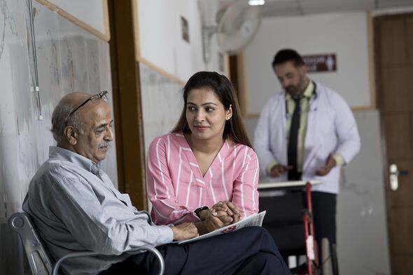 Daughter consoling sad senior man in waiting room