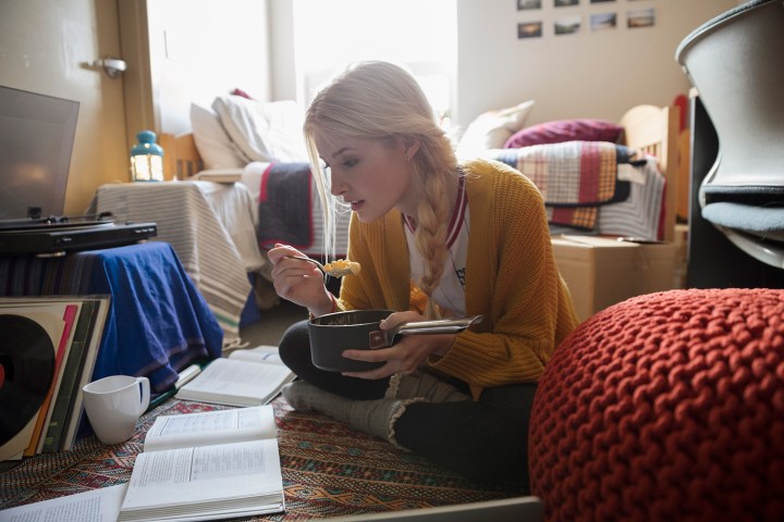 A student eating mac and cheese while studying. 