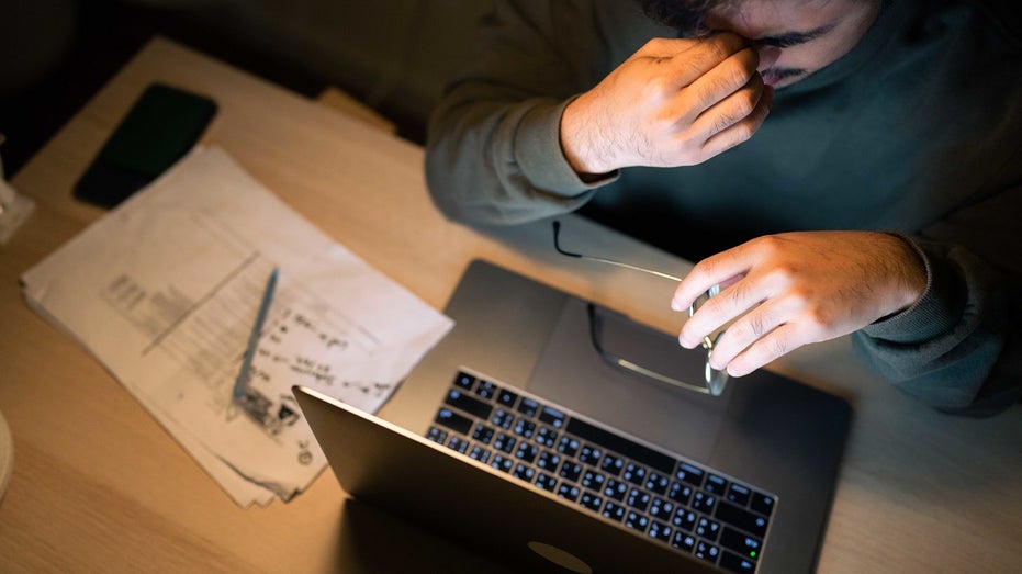 man stressed while going over bills