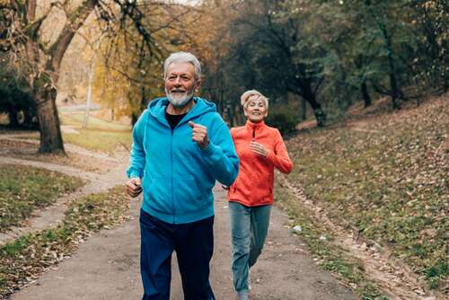 Older couple jogging in a park