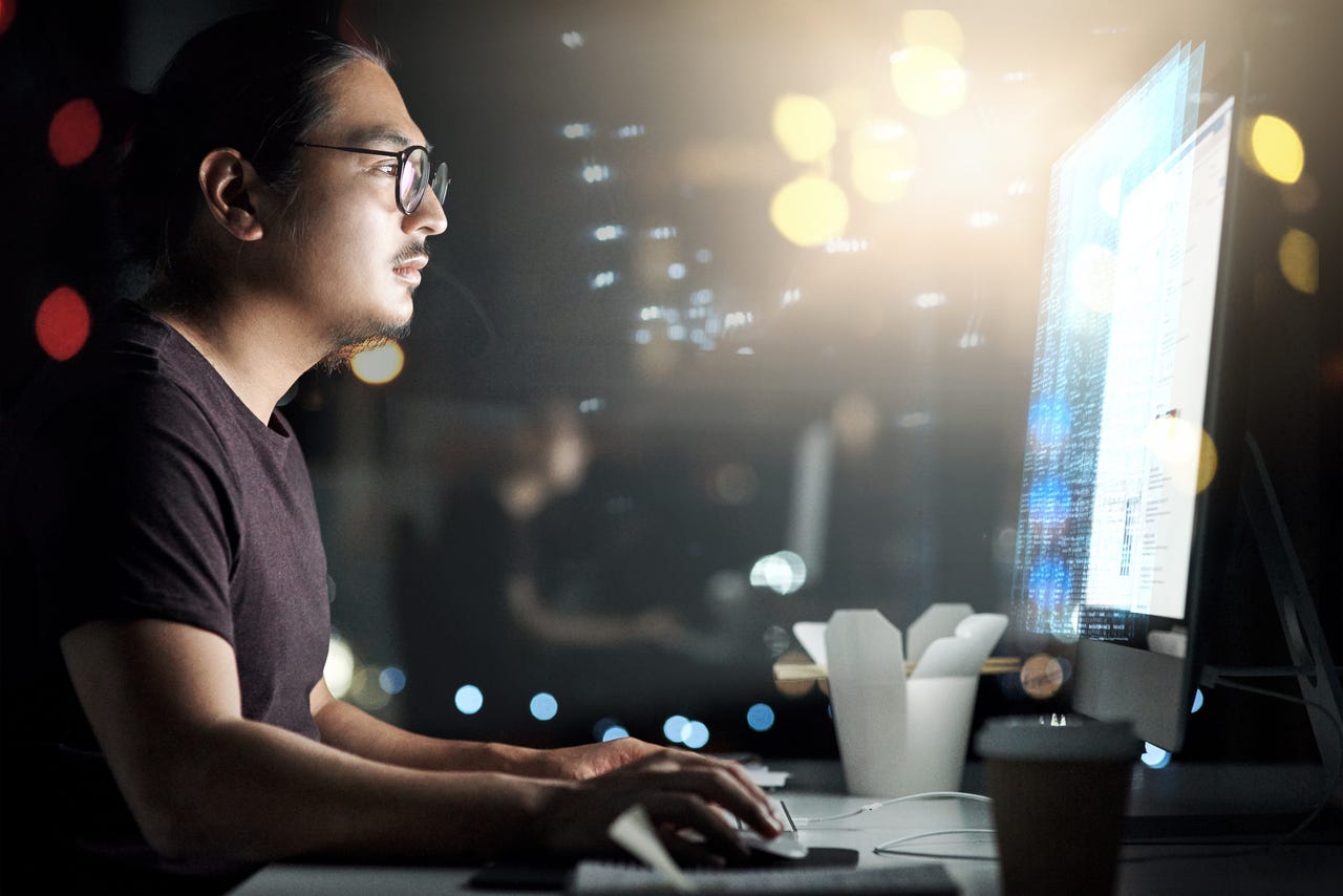 Male computer programmer working late in the office on a new code