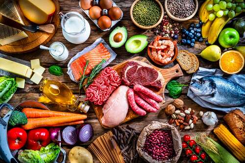 Table filled with large variety of food high in iron like red meat, iron, lentils and eggs