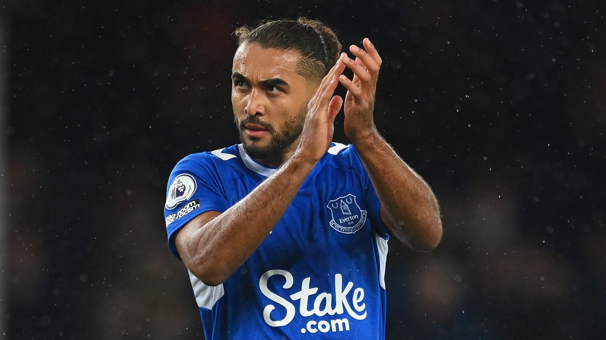 Everton striker Dominic Calvert-Lewin with his hands raised applauding in the rain.