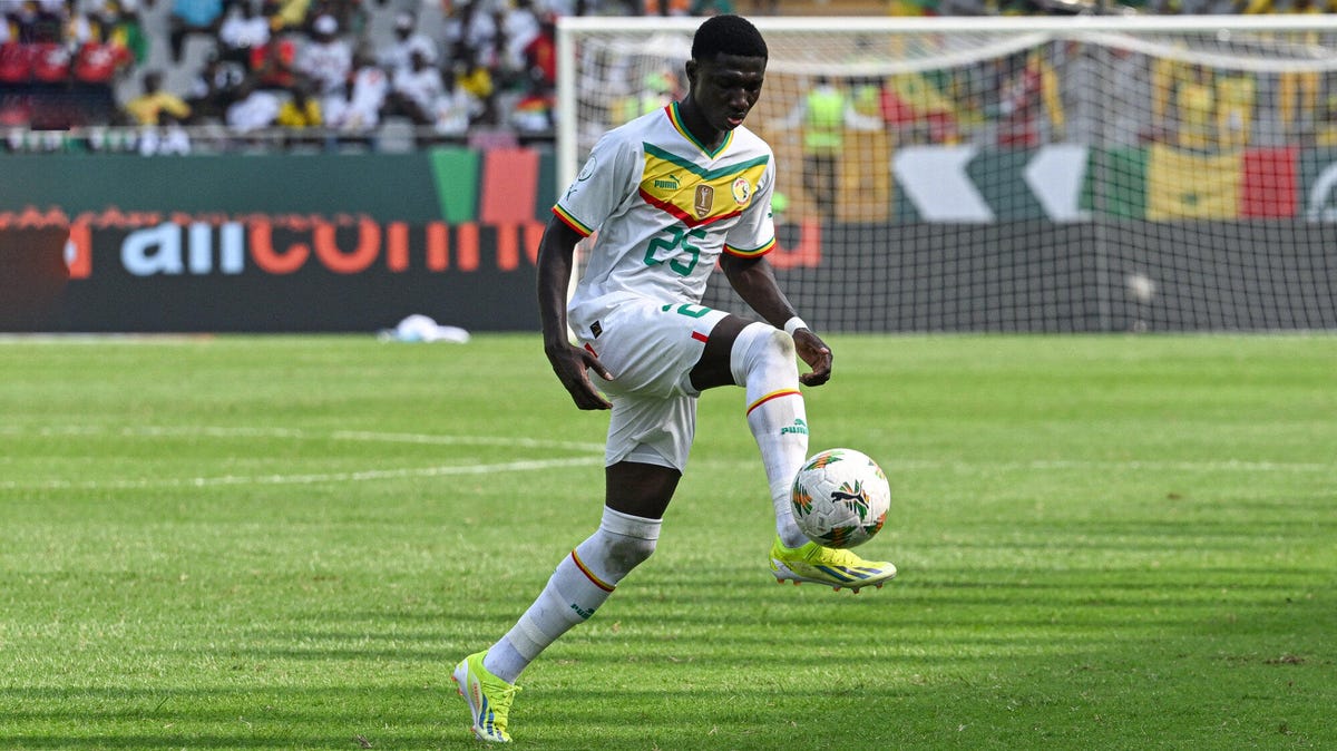 Senegal midfielder Lamine Camara controlling the ball with his right foot.