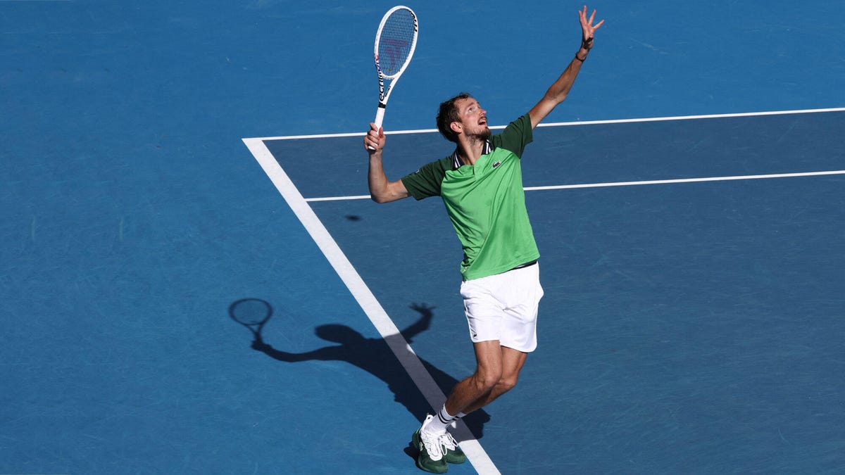 Tennis player Daniil Medvedev serving a ball with his right hand.