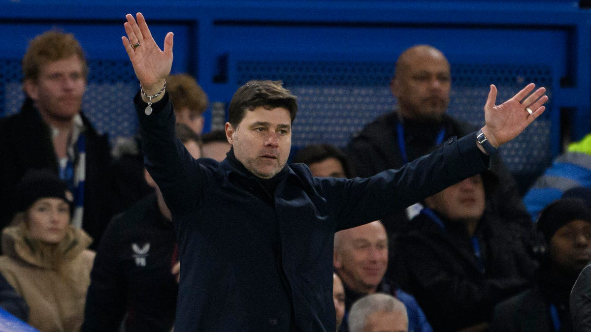 Chelsea manager Mauricio Pochettino standing with both arms aloft.