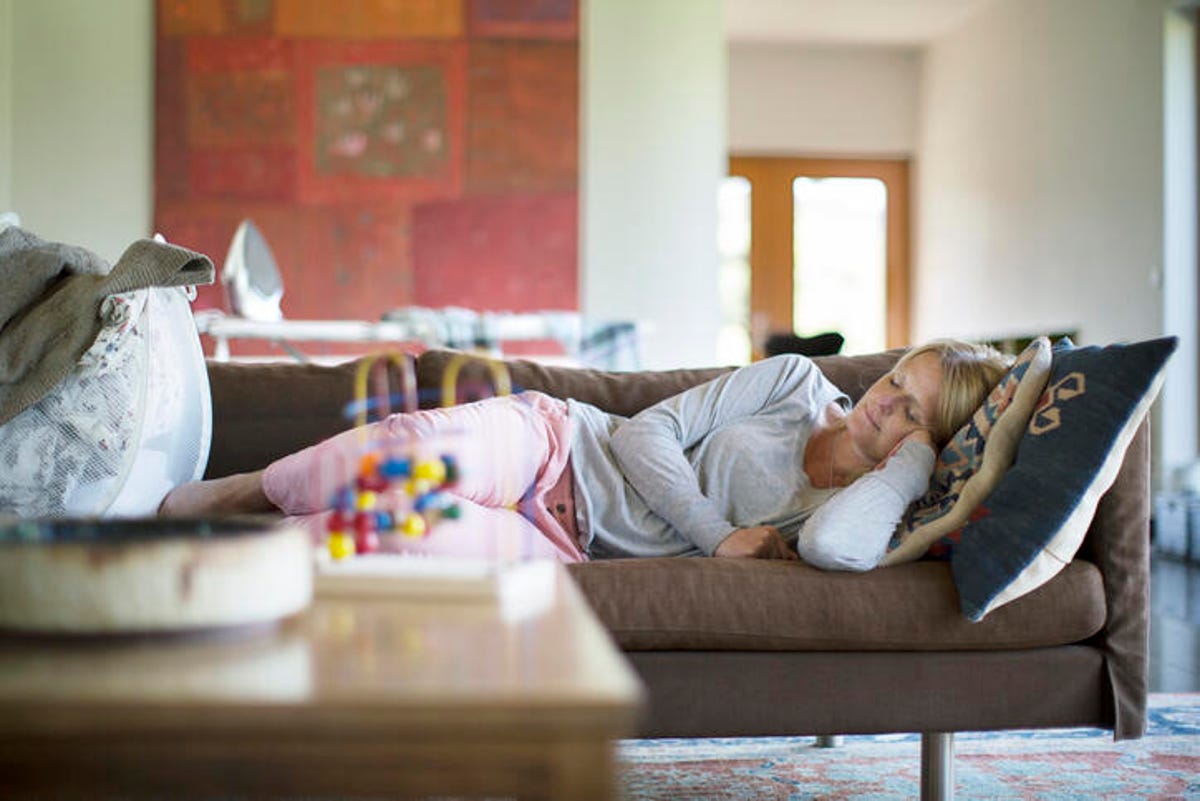 Woman napping on the couch in the middle of the day.