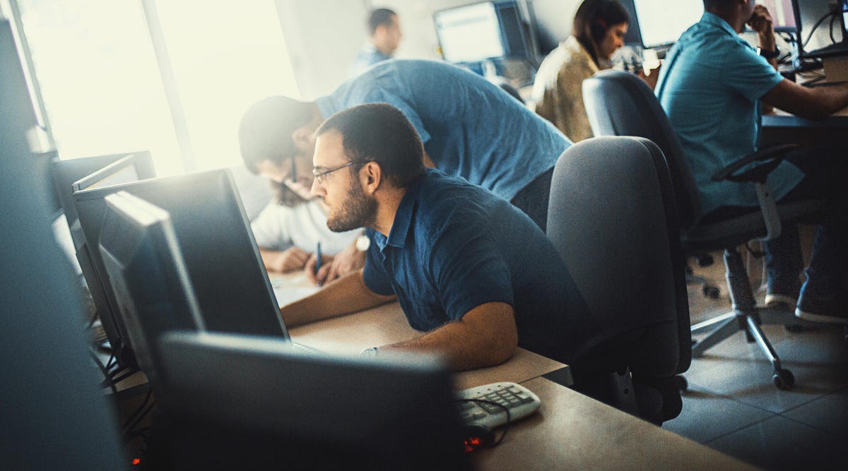 A man leaning into his computer