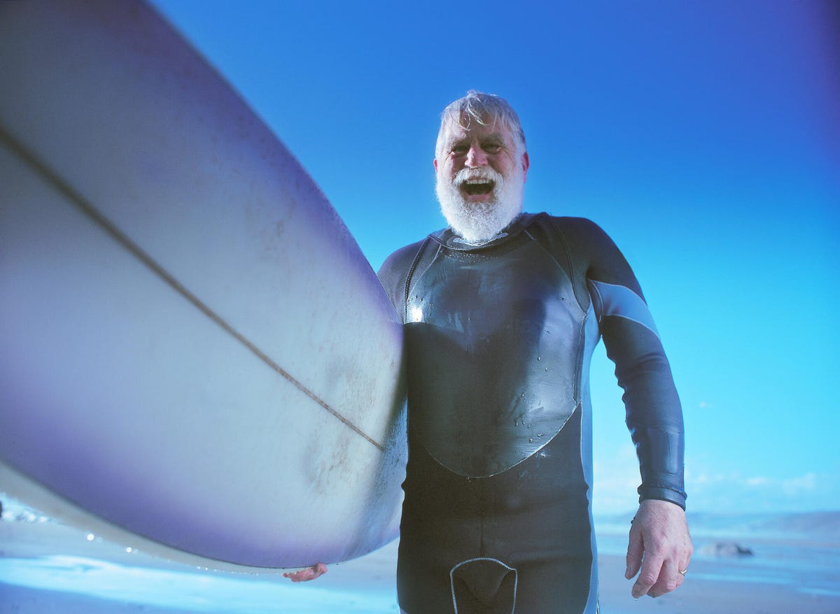 Bearded man holding surfboard in the water