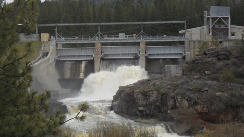 Image of water flowing through the open gates of a dam.