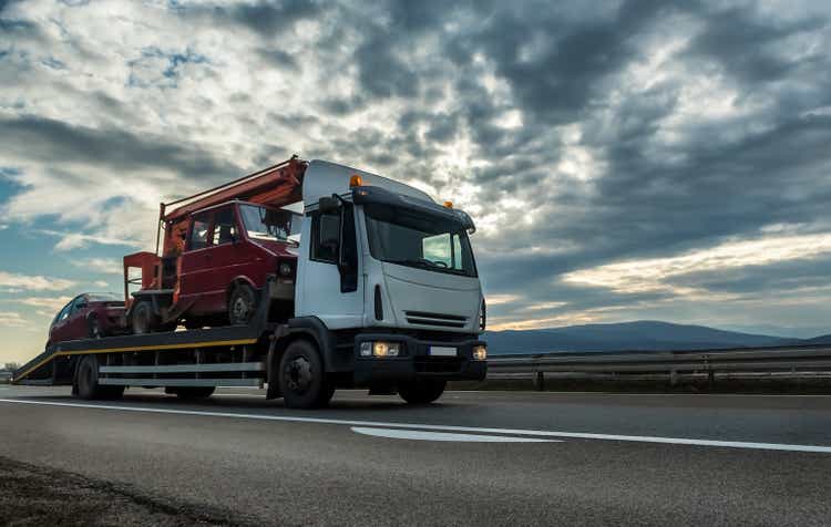 Tow truck or Flatbed truck towing two vehicles