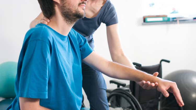 Physiotherapist with disabled person