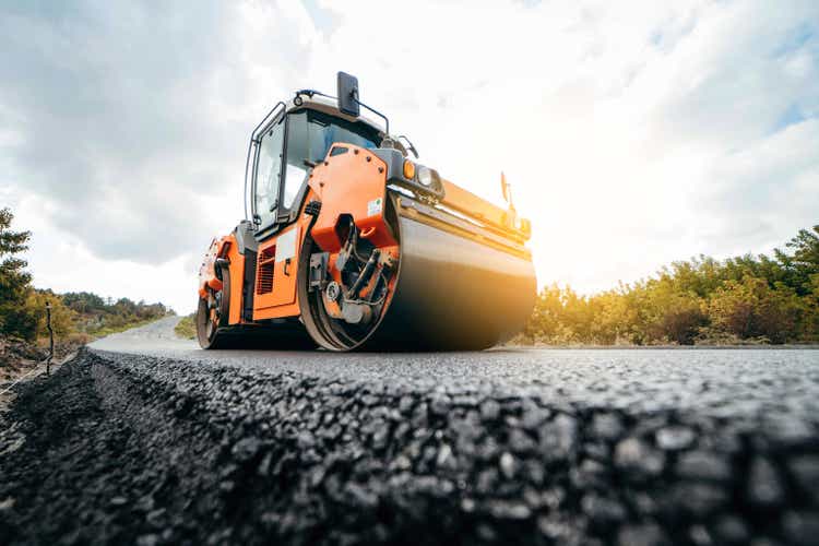 Vibratory asphalt roller compactor compacting new asphalt pavement. Road service repairs the highway