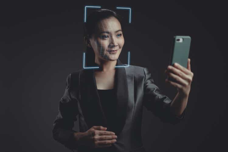 Asian woman scans face by smart phone using facial recognition system.