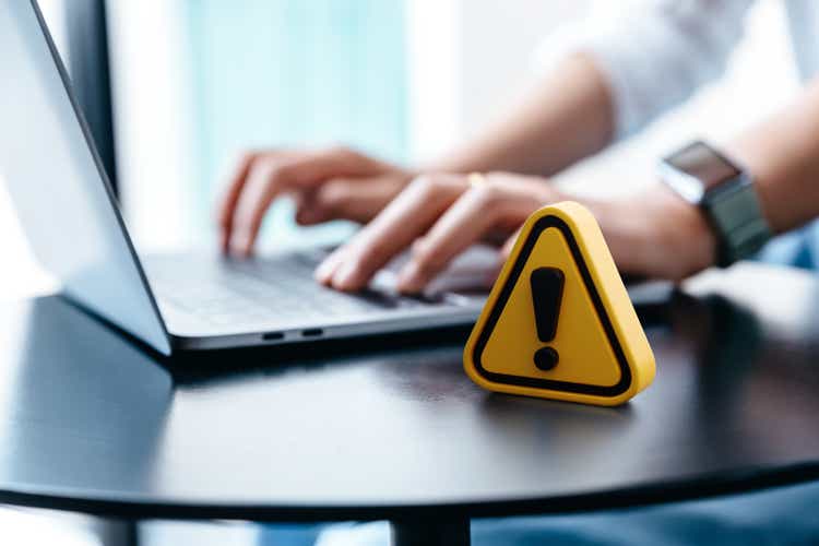 Warning sign placed on a table while businesswoman work.