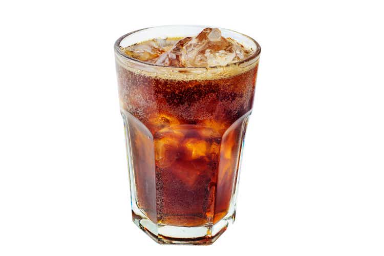 Cola with ice in a glass. Beautiful foam and air bubbles in a sweet carbonated drink