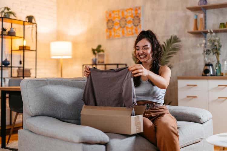 Young Woman Unboxing A Package With A New Shirt